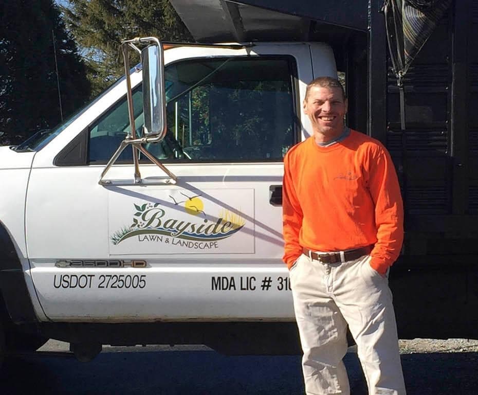 Craig Stitcher, owner of Bayside Tree and Landscape, standing beside the company's licensed and insured work truck on Maryland's Eastern Shore
